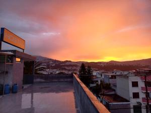 uma vista para o pôr-do-sol a partir do telhado de um edifício em El Vergel Norte em Quito