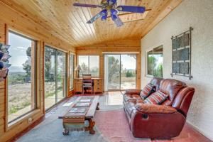 sala de estar con sofá de cuero y ventilador de techo en Pet-Friendly Mountaintop Retreat with Views and Sauna, en Prescott Valley