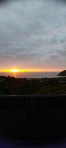 a sunset over the ocean with the sun in the distance at Casa Yogui Brasil in Garopaba