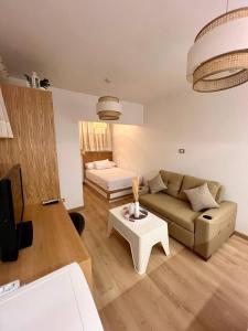 ein Wohnzimmer mit einem Sofa und einem Tisch in der Unterkunft Paradise Studios in Sheikh Zayed