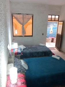 Habitación de hotel con 2 camas y ventana en salt beds of salt hostal en Uyuni