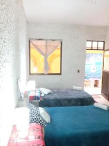 烏尤尼的住宿－salt beds of salt hostal，一间卧室设有两张床和窗户。