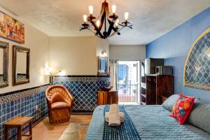 a bedroom with blue walls and a bed and a couch at Casa de Colores in Guanajuato