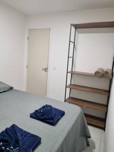 a bedroom with a bed with blue sheets and a ladder at Apto próximo ao Pátio do Forró in Caruaru +14 photos