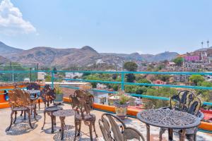 a group of tables and chairs on a balcony with mountains at Casa de Colores in Guanajuato