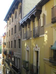 un edificio amarillo con balcones en una calle en Apartamentos Turísticos Reyes Católicos, en Zaragoza