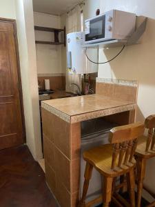 布宜諾斯艾利斯的住宿－Hermoso monoambiente，厨房配有带2把椅子的柜台和微波炉