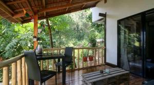 Un balcón de una casa con una mesa y sillas. en The Piupiu Nest, en Iriga City