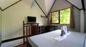 Un dormitorio con una cama y un televisor y una ventana. en The Piupiu Nest, en Iriga City