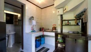 una pequeña cocina con lavabo y aseo en The Piupiu Nest, en Iriga City