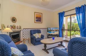 een woonkamer met blauwe stoelen en een tafel bij Vila Telo in Luz