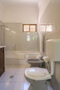 een witte badkamer met een toilet en een wastafel bij Vila Telo in Luz