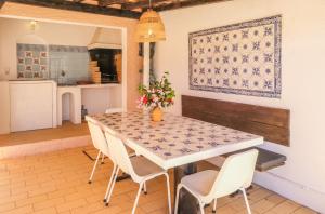 een keuken en eetkamer met een tafel en stoelen bij Vila Telo in Luz