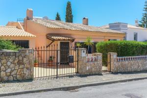 een huis met een hek en een stenen hek bij Vila Telo in Luz