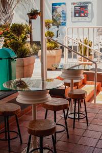 two tables and stools on a patio with plants at Pousada Iguassu Charm Suites in Foz do Iguaçu