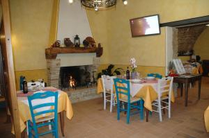 a dining room with tables and chairs and a fireplace at Agriturismo Casale La Palombara in Cerreto di Spoleto