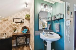 La salle de bains est pourvue d'un lavabo et d'un miroir. dans l'établissement Sea Breeze Manor Inn, à St Petersburg