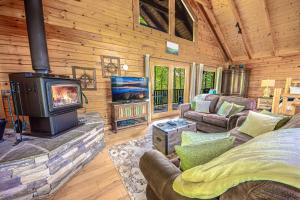 a living room with a fireplace and a stove at Love Me Tender Studio Cabin in Sevierville