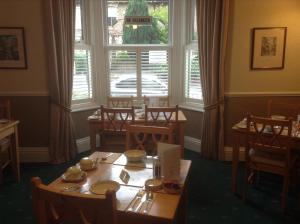 a dining room with a table and a large window at Chelmsford Place Guest House in York