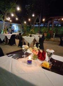a table with a candle on a white table cloth at wisma sejahtera hotel in Magelang