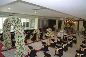 a banquet hall with chairs and a large arch with flowers at wisma sejahtera hotel in Magelang