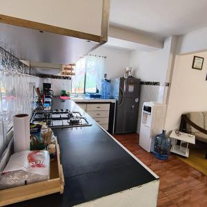 a kitchen with a large black counter top at Hostal Villa del Sol in Salento