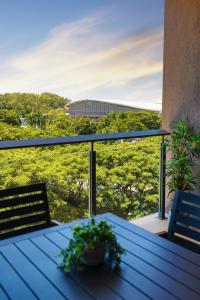 - une table sur un balcon avec vue sur un bâtiment dans l'établissement Oceania at Darwin Waterfront, à Darwin