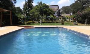 a swimming pool in a yard with a house at Hotel Troy in Nairobi