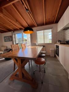 a kitchen with a large wooden table and chairs at Little Champ in Bicheno
