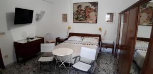 a bedroom with a bed and a table and chairs at Casa Relax nel centro storico con posto auto in Vico Equense