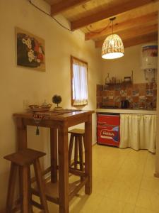 una cucina con tavolo e sgabelli in legno di Cabaña "Amanecer" a Chilecito