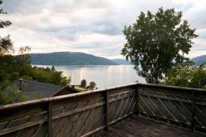 a view of a lake from a wooden fence at Fjordhytte-2 am Hardangerfjord, grandioses Fjordpanorama, 20 PS Motorboot mietbar! in Ænes