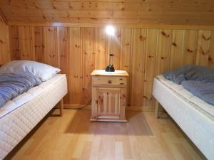 a room with two beds and a table with a lamp on it at Fjordhytte-16 direkt am Sognefjord in Bjordal, mit mietbaren 9,9 PS bis 60 PS Motorbooten in Bjordal