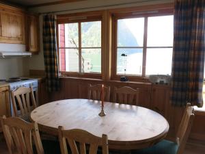 a kitchen with a wooden table with a candle on it at Fjordhytte-23 direkt am Sognefjord, mit mietbaren Motorbooten 9,9-60 PS in Bjordal