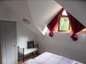 una camera da letto con un letto e una finestra con tende rosse di Ferienland Sonnenwald Fewo 46 und Studio 50 in Schöfweg Bayerischer Wald a Schöfweg Altre 50 foto
