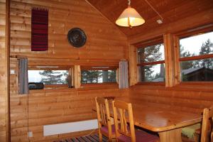 a dining room in a log cabin with a wooden table and chairs at Fjordhytte-40 im Vestland - Hordaland nahe Rosendal in Rosendal