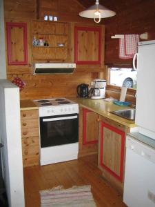cocina con armarios de madera y horno de fogón blanco en Fjordhytte-38 bei Rosendal am Hardangerfjord, en Rosendal 22 fotos más