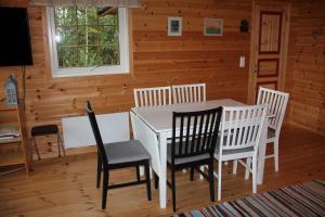 a dining room with a white table and chairs at Fjordhytte-39 am Hardangerfjord, Motorboot mietbar in Rosendal