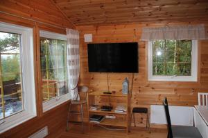 a living room with a television in a log cabin at Fjordhytte-39 am Hardangerfjord, Motorboot mietbar in Rosendal