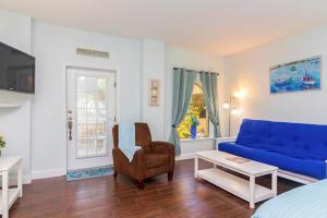 uma sala de estar com um sofá azul e uma cadeira em Inn at Camachee Harbor Garden View 15 em Saint Augustine