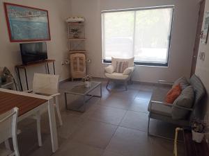 uma sala de estar com um sofá, uma televisão e uma mesa em Casa Privada en Puerto Morelos em Puerto Morelos