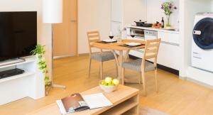 sala de estar con mesa y cocina con lavadora en Fraser Residence Nankai Osaka, en Osaka