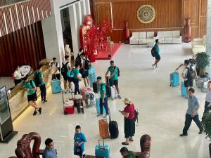 un gruppo di persone in piedi nella hall con bagagli di Tre Xanh Hotel a Pleiku