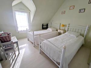 2 weiße Betten in einem Zimmer mit Fenster in der Unterkunft Maison Sarzeau, 3 pièces, 4 personnes - FR-1-639-19 in Sarzeau