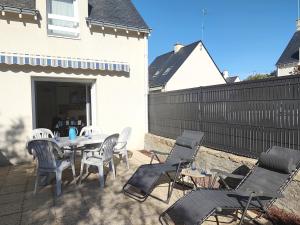 eine Terrasse mit einem Tisch, Stühlen und einem Zaun in der Unterkunft Maison Sarzeau, 3 pièces, 4 personnes - FR-1-639-19 in Sarzeau
