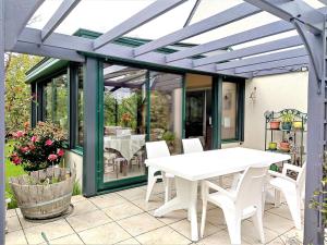 eine Terrasse mit einem weißen Tisch und weißen Stühlen in der Unterkunft Maison 6 pers, 600m plage, jardin, barbecue, parking - FR-1-639-92 in Sarzeau