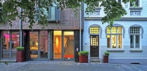 un magasin à l'avant d'un bâtiment avec portes en verre dans l'établissement Hotel im Wigbold, à Ochtrup