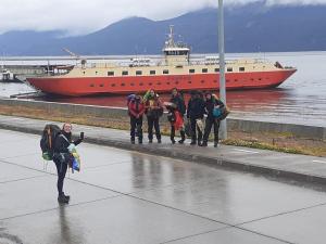a group of people standing in front of a large boat at Refugio Jemmy Button in Puerto Williams