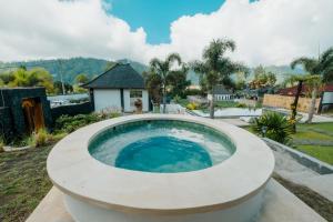 a circular pool in a yard with a house at Mount Batur Villa in Kintamani