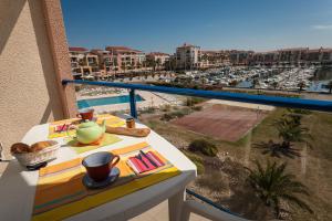 d'un balcon avec une table et une vue sur le port. dans l'établissement Résidence Mer & Golf Port Argelès, à Argelès-sur-Mer